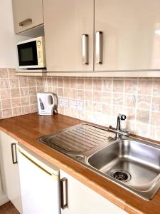a kitchen counter with a sink and a microwave at Inn Glastonbury - Self Catering in Glastonbury