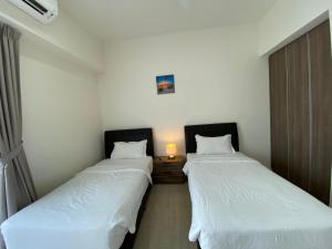 two beds in a small room with a light between them at By The Sea@Sunset view and Seaview #32 in Batu Ferringhi +38 photos