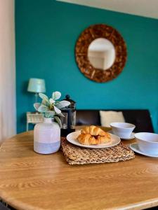 Inn Glastonbury - Self Catering في غلاستونبري: طاولة مع صحن من الكرواسون ومرآة