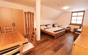 um quarto com 2 camas e uma mesa em Hotel Vydrovy Boudy em Pec pod Sněžkou