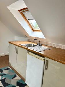 a kitchen with a sink and a skylight at Inn Glastonbury - Self Catering in Glastonbury