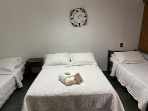 a room with two beds and a book on the bed at POUSADA PALIPALAN in Sao Jorge