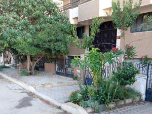 ein Gebäude mit einem Zaun und einigen Bäumen und Pflanzen in der Unterkunft Safe House in Kairo