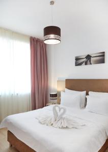 Кровать или кровати в номере Excelsior Apartaments Mamaia Nord