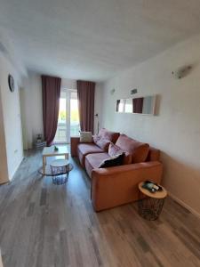 sala de estar con sofá marrón y mesas en Nemira beach apartments, en Omiš