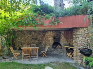 een stenen huis met een tafel en stoelen en een open haard bij Villa Remata in Handlová