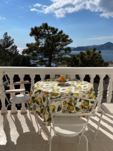 een tafel en stoelen op een balkon met een tafelkleed erop bij Apartments Sana in Sveti Stefan