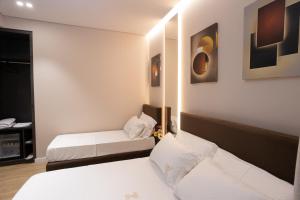 a hotel room with two beds and a mirror at Bee Hotel in Vlorë