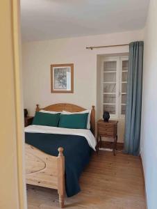 a bedroom with a large bed with blue pillows at Joli gîte pour 5 personnes : Chez Cherrie in Saint-Julien-de-Lampon