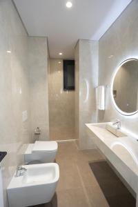 a bathroom with a sink and a toilet and a mirror at Bee Hotel in Vlorë
