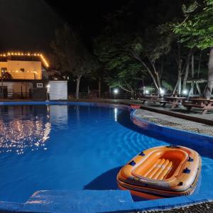 an orange boat sitting in a swimming pool at night at Namhae Beach Hotel in Namhae