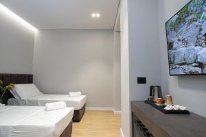 a room with two beds and a flat screen tv at Bee Hotel in Vlorë