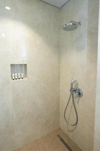 a shower with a shower head in a bathroom at Bee Hotel in Vlorë