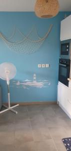 eine Küche mit einer Wand mit einem Gemälde eines Leuchtturms in der Unterkunft Appartement Centre de La Teste in La Teste-de-Buch