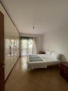 een slaapkamer met een groot bed en een glazen schuifdeur bij Daily Apartment in Tirana