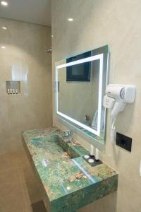 a bathroom with a sink and a mirror at Bee Hotel in Vlorë