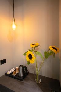 a vase with yellow flowers sitting on a table at Bee Hotel in Vlorë