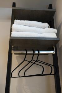 a towel rack with white towels on it at Bee Hotel in Vlorë