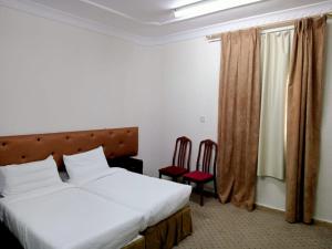 Un pat sau paturi într-o cameră la فندق نبض الضيافة 1 - العزيزية الشارع العام
