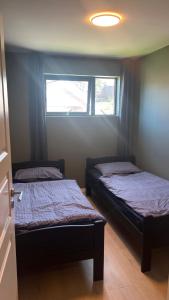 2 camas en una habitación pequeña con ventana en Moderne Leilighet med panorama utsikt, en Sandefjord