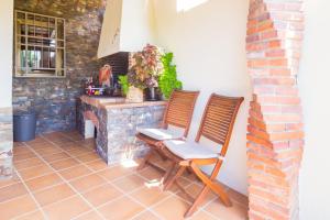 duas cadeiras sentadas em frente a uma lareira de tijolos em Villa Del Sol em Santa Cristina d'Aro