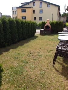 a yard with a building and a grill at Seeperle Große Fewo in Papendorf
