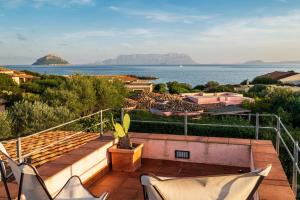 a balcony with chairs and a view of the water at Villa Ponente in Golfo Aranci