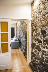 een kamer met een stenen muur en een deur bij Aizpuri Rose View in Nīca