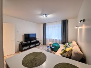 a living room with a couch and a tv at Tammsaare 28 Beach Apartment in Pärnu