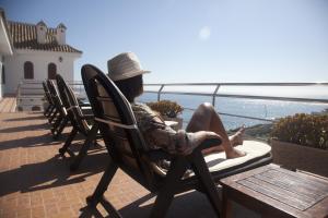 a woman sitting in a chair looking out at the ocean at Hostal Mar de Frente in Los Caños de Meca