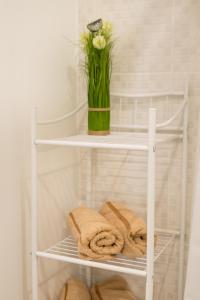 a white shelf with towels and a vase of flowers at Tammsaare 28 Beach Apartment in Pärnu +15 photos