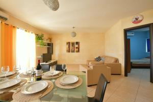 ein Esszimmer mit einem Tisch und ein Wohnzimmer in der Unterkunft Gozo Spacious Apartment with Large Communal Pool in Qala