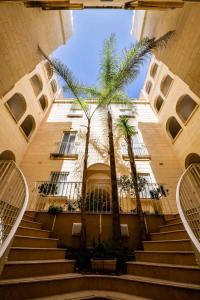 ein Gebäude mit Palmen davor in der Unterkunft Gozo Spacious Apartment with Large Communal Pool in Qala