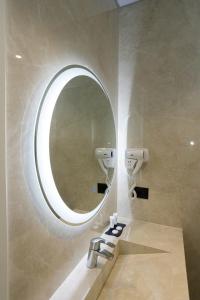 a bathroom with a mirror and a sink at Bee Hotel in Vlorë