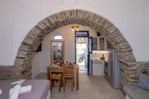 Kalloni Tinou的住宿－Βόλτα Καλλονή studio (Volta Kalloni)，厨房以及带石拱门的用餐室