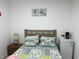 1 dormitorio con 1 cama con almohadas y nevera en Techas City Center Luxurious Suites & Rooms en Praia