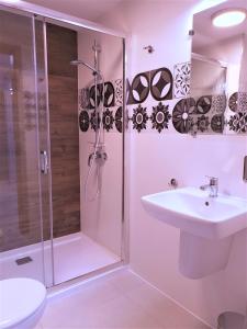 a white bathroom with a shower and a sink at Hostel Annamarie in Szczecin