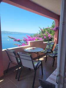 balcón con sillas, mesa y vistas al océano en Apartments Coko, en Omiš