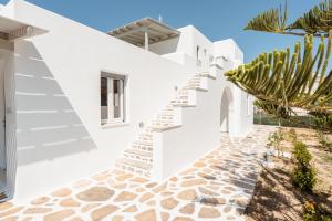 une maison blanche avec des escaliers et un cactus dans l'établissement Celestial Seaview Apartments- Ariadne, à Naxos Chora