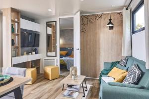 uma sala de estar com um sofá azul e uma mesa em Camping Country Park Crecy La Chapelle - Site Officiel - Next to Disneyland Paris em Crecy la Chapelle