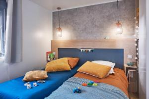 克雷西拉沙佩勒Camping Country Park Crecy La Chapelle - Site Officiel - Next to Disneyland Paris的卧室里有一张床，上面铺着蓝色毯子 更多30张照片