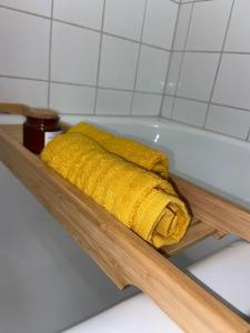 a yellow towel is sitting in a bath tub at Adler Apartment in Cologne