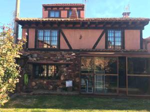 una vecchia casa con un edificio in pietra con finestre di Exclusiva casa rural con jardín a Madriguera