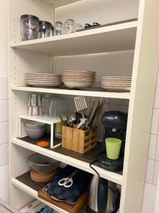 a kitchen pantry with plates and utensils at Adler Apartment in Cologne