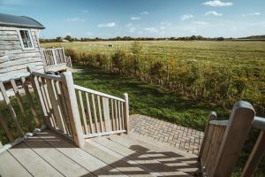 a wooden staircase leading to a house with a field at Hornington Manor Luxury Shepherd Huts in York