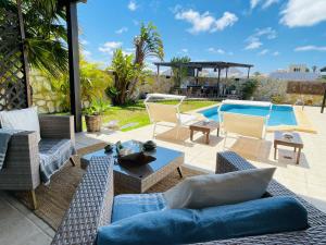 eine Terrasse mit Gartenmöbeln und einem Pool in der Unterkunft Kalufa Surf House in El Cuchillo