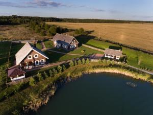 an aerial view of a house and a lake at Viešbutis SAKAI sodyboje Gribžė in Gribžiniai