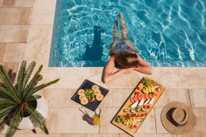 a woman laying in a swimming pool next to a table of food at Skansen Bicz Resort in Stare Miasto