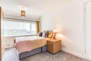 a bedroom with a bed and a window at Delightful Garforth Home in Garforth