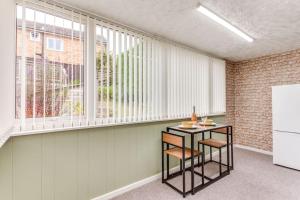 Habitación con mesa pequeña y ventana. en Delightful Garforth Home, en Garforth